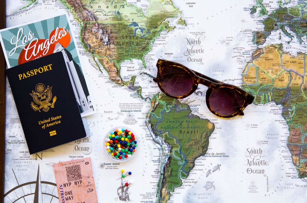 Passport and sunglasses sitting on a map