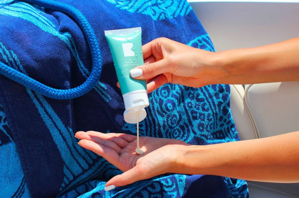 Woman's hands applying sunscreen