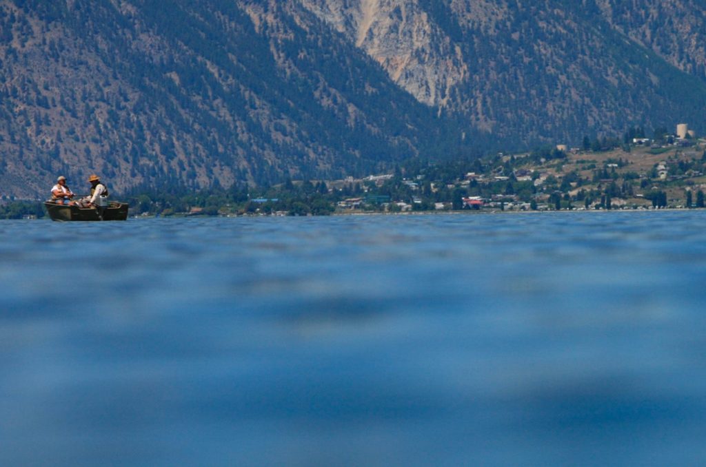 Low angle view of the Lake Chelan water line with fisherman on a boat