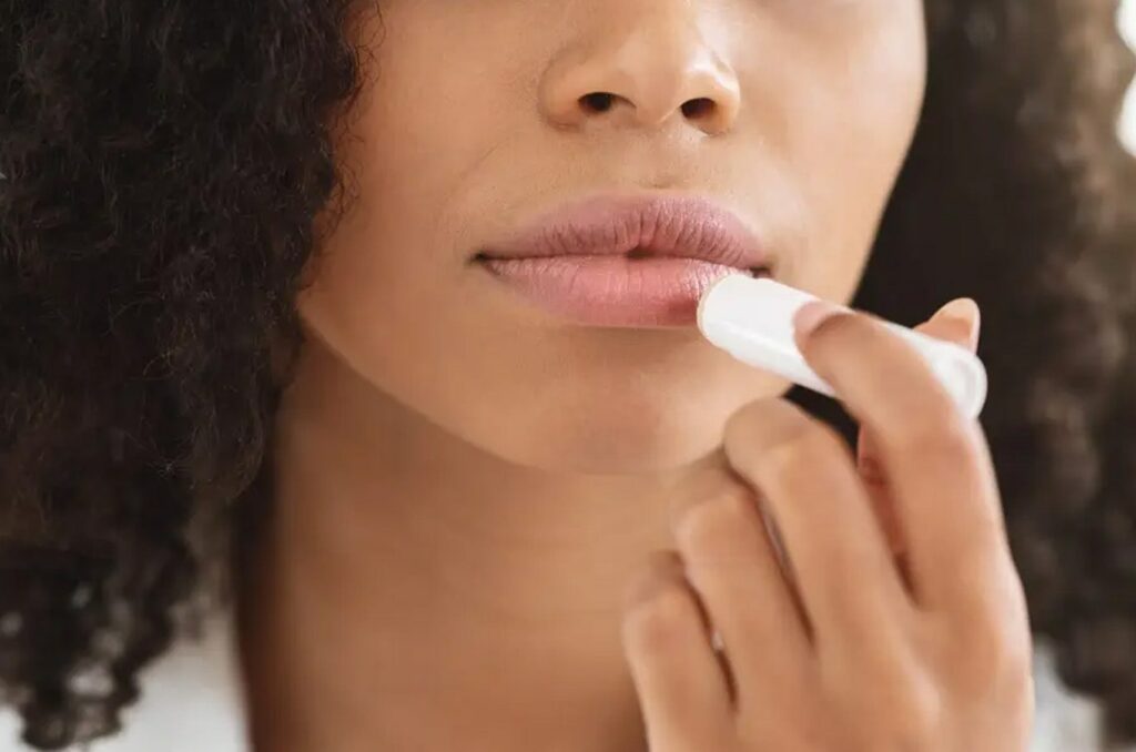Woman applying chapstick to her lips
