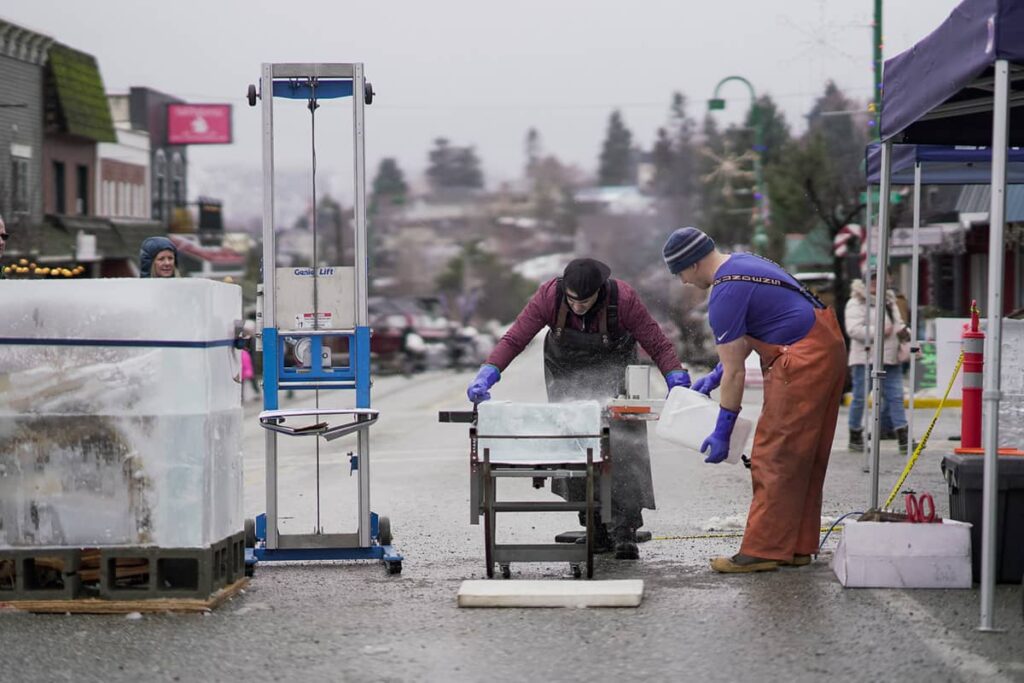 Men carving out blocks of ice for Winterfest 2023