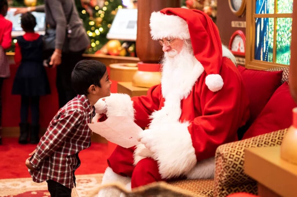 Santa Claus getting a Christmas gift list from a child